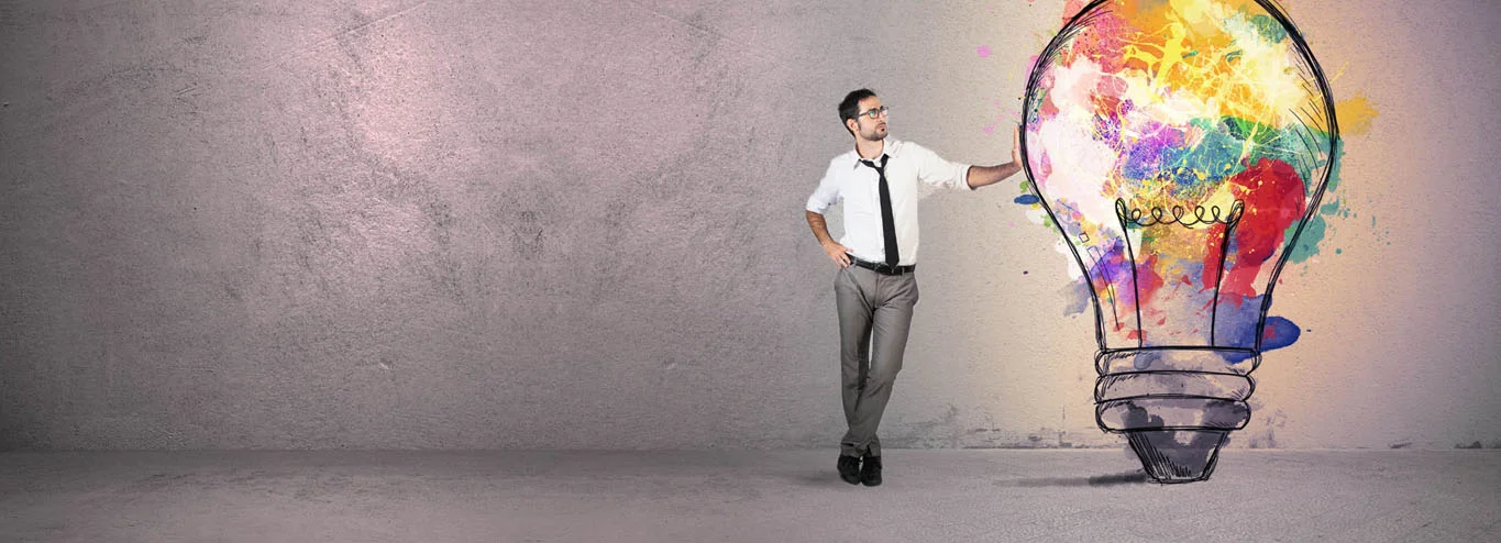 Businessman leaning on artistic lightbulb