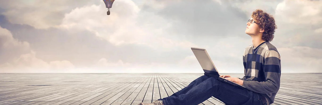 Person daydreaming while using a laptop.